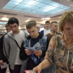 Посетители в фойе рассматривают информационные буклеты