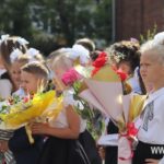 Дети в праздничной школьной одежде с букетами цветов