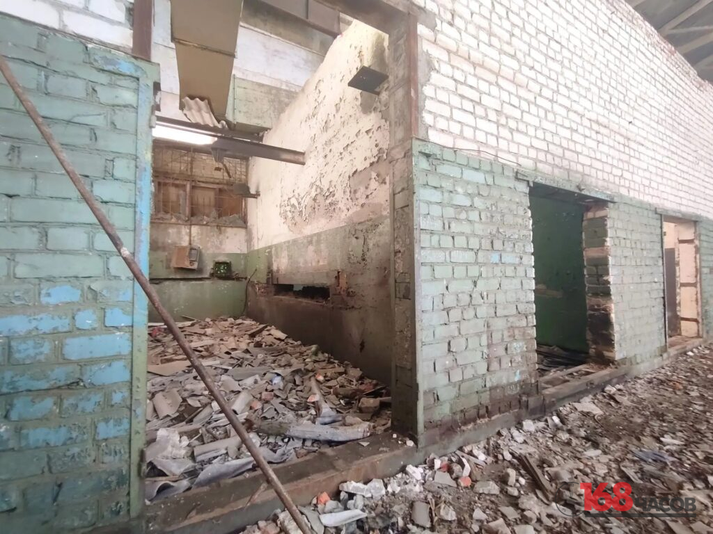 Полуразрушенные кирпичные помещения с облупившимися стенами и грудами строительного мусора