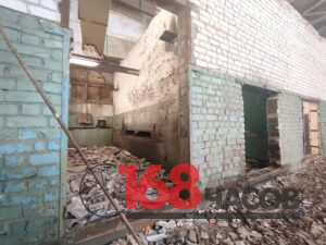 Полуразрушенные кирпичные помещения с облупившимися стенами и грудами строительного мусора
