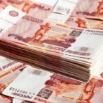 Стопка российских банкнот номиналом 5000 рублей на россыпи купюр