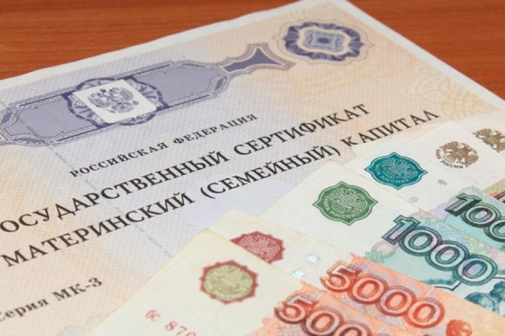 Государственный сертификат на материнский капитал и российские банкноты номиналом 5000 и 1000 рублей