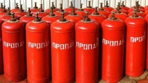 Красные газовые баллоны с надписью «ПРОПАН», установленные в ряду