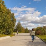 Сухой раннеосенний день на нейтральной городской дорожке: переменная облачность, лёгкий ветер и люди на прогулке