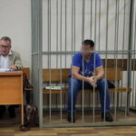 Мужчина на скамье подсудимых за решёткой в зале суда