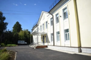 Заасфальтированная площадка у входа в двухэтажное светлое здание школы
