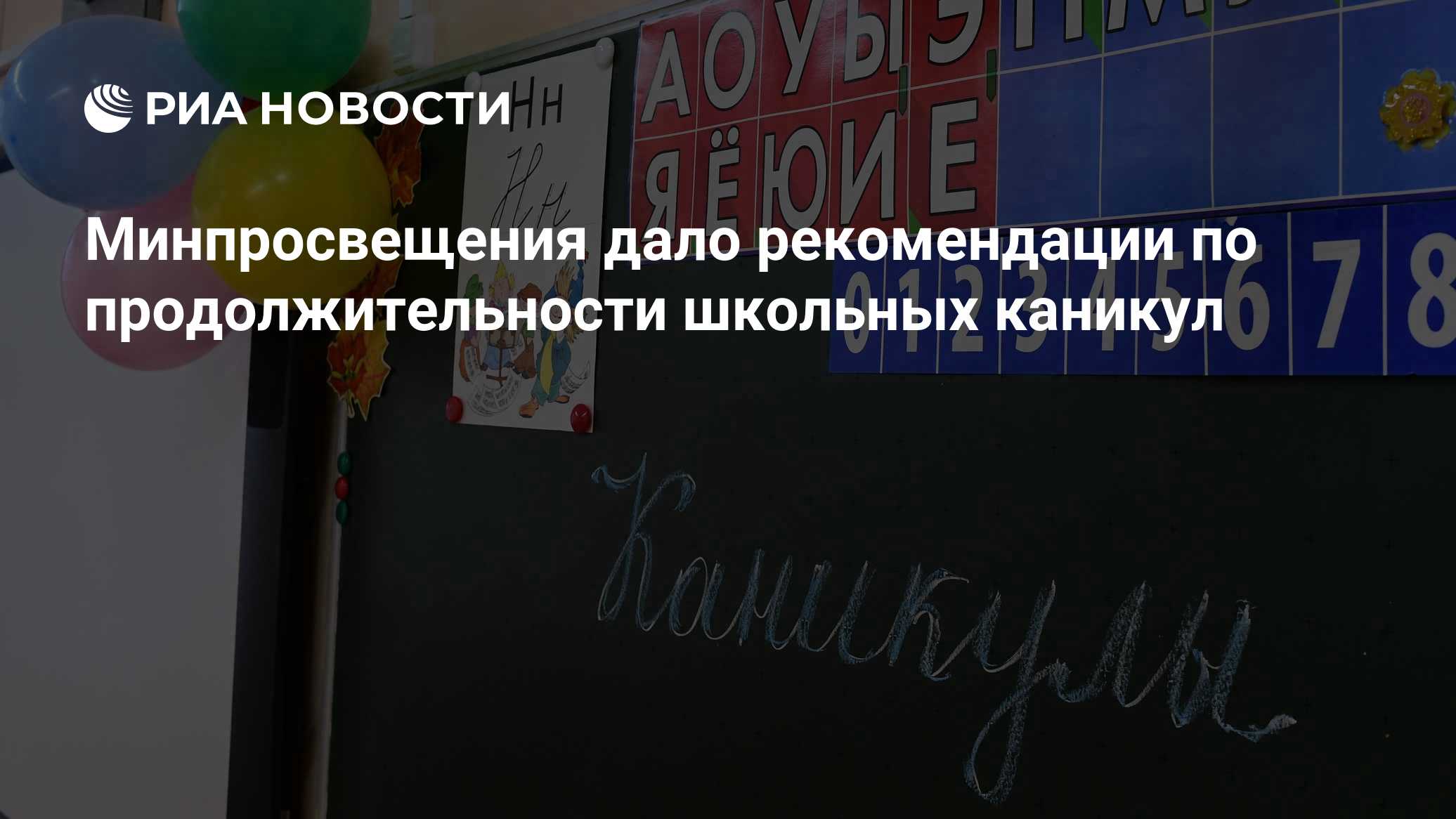 Фрагмент школьного класса: чёрная доска с мелом, учебные карточки и цифровые плитки на стене, праздничные шарики; поверх — логотип и заголовок новостного сайта.