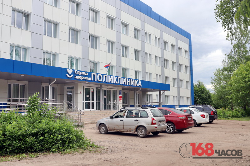 Фасад поликлиники с входом, пандусом и припаркованными автомобилями