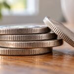 Монеты на деревянном столе крупным планом; хорошо видны насечки на боковых краях.