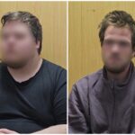 Двое молодых мужчин с размытыми лицами сидят на фоне деревянной стены