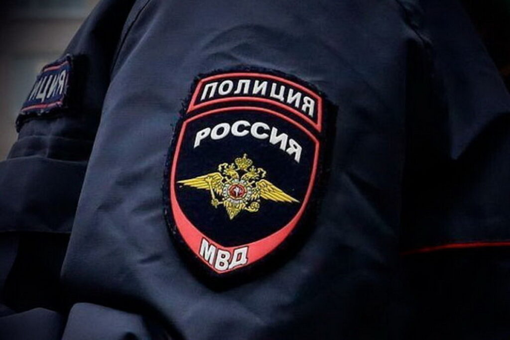 Крупный план нашивки «Полиция России МВД» на рукаве тёмно-синей форменной куртки