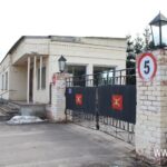 одноэтажное нежилое здание с въездными воротами и кирпичными столбами
