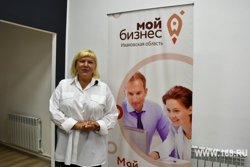 Женщина на фоне ролл‑апа «Мой бизнес» в офисном помещении