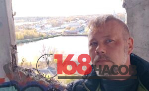 Мужчина на фоне реки и городской застройки в проёме разрушенной бетонной стены