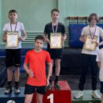Юные легкоатлеты с медалями и грамотами в спортивном зале