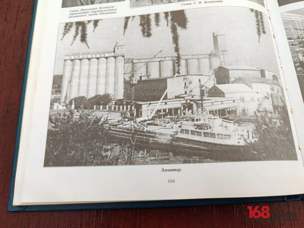 Открытая книга с чёрно-белой фотографией элеватора и пришвартованных у берега судов
