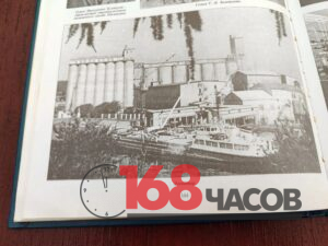 Открытая книга с чёрно-белой фотографией элеватора и пришвартованных у берега судов