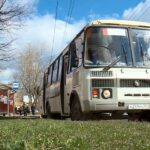 Пассажирский автобус на остановке, люди на тротуаре, весенний день