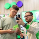 Консультант помогает покупателю выбрать смартфон в магазине мобильной связи
