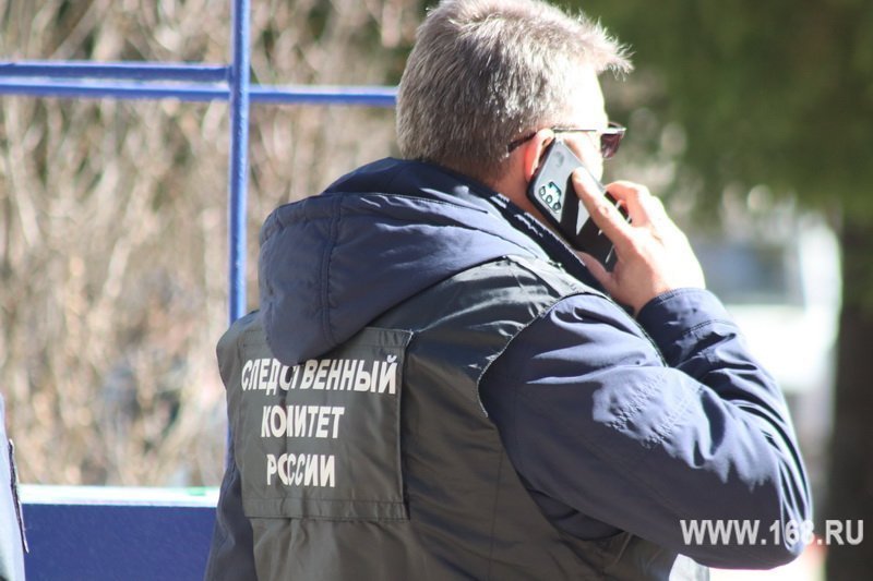 Сотрудник в жилете с надписью «Следственный комитет России», говорит по телефону; водяной знак www.168.ru внизу кадра.
