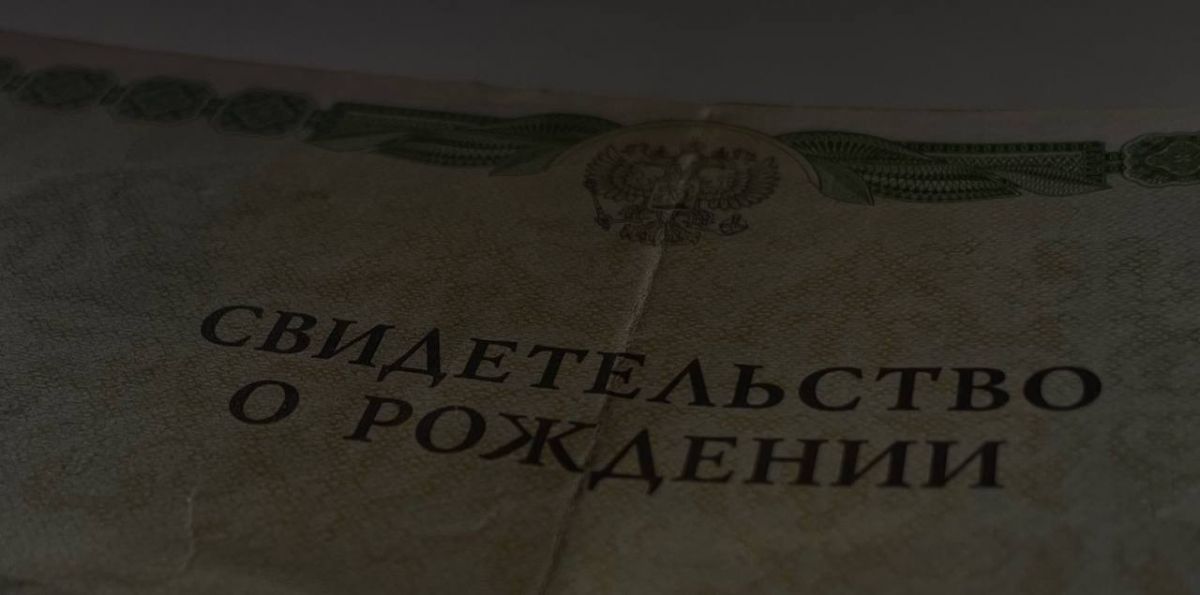 Фото развёрнутого бланка свидетельства о рождении с крупной надписью.