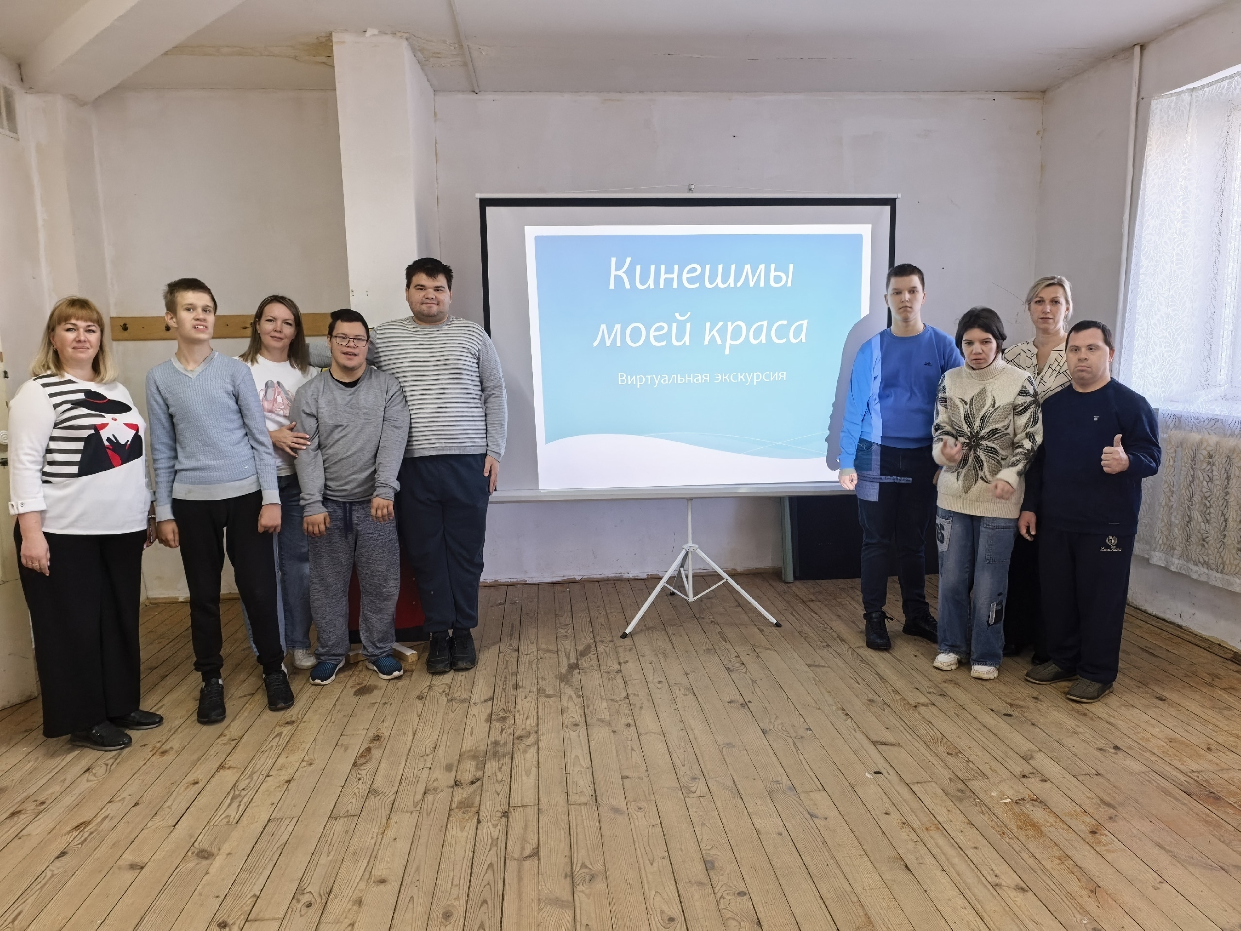Группа людей стоит в помещении у проекционного экрана с надписью «Кинешмы моей краса. Виртуальная экскурсия»