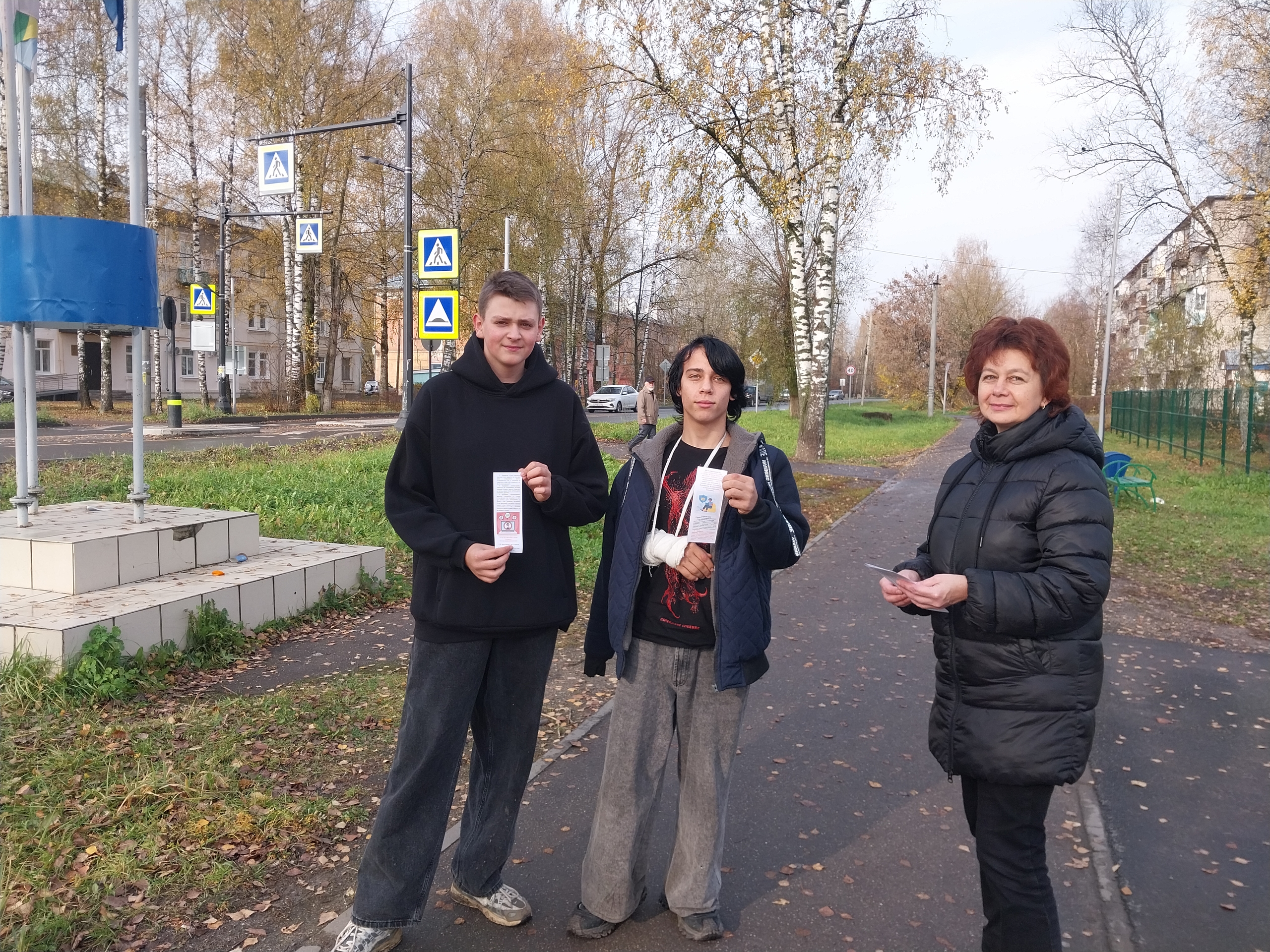 три человека на тротуаре держат длинные бумажные закладки (карманные памятки)